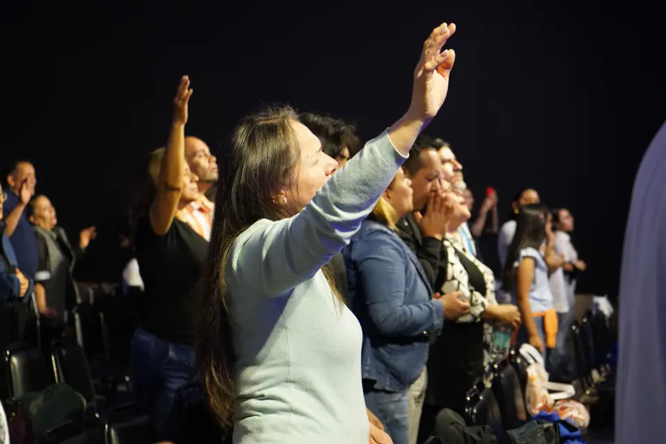 Congregación adorando con las manos en alto durante un culto en Pudahuel