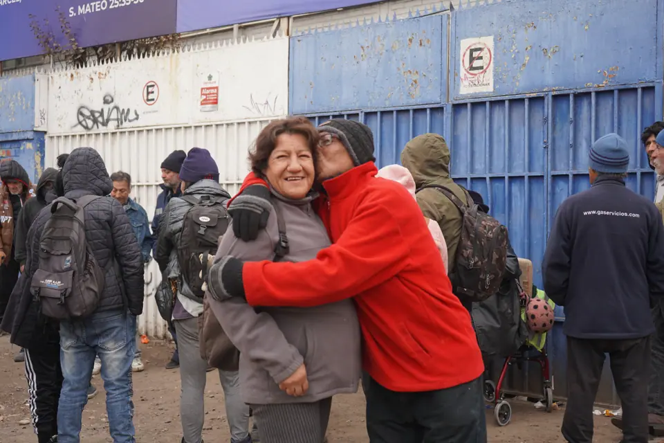 Voluntaria del Comedor Abierto abrazando a una persona que recibe almuerzo