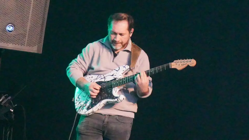 Músico tocando guitarra durante el servicio en Linares